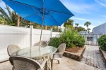 Patio with table, umbrella,  and chairs leading to the pool 