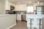 Brand new cabinets and tiled backsplash brightens up the remodeled kitchen