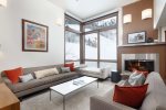 The warm and inviting living room features a gas fireplace, flat screen TV, plenty of seating and views of Aspen Mountain.