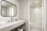 The upstairs bathroom can be accessed from the twin bedroom or the hallway. The bath has a separate vanity area.