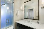 The downstairs master bath feels luxurious with a rain shower and marble countertops and tiles.