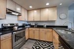 Kitchen with stainless steel appliances and black granite countertops