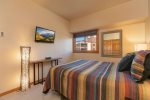 Guest bedroom with queen bed and tv