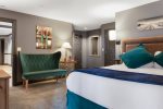 Bedroom 3, located off of the kitchen, features a King Bed and Seating Area.