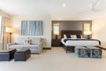 Spacious primary bedroom featuring a king bed and a queen sleeper sofa, perfect for relaxation and accommodating guests