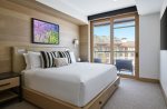 Plush king bed with leather headboard, integrated reading lights, and premium linens