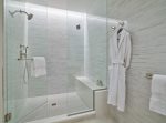 Spacious en suite with a shower, quartz vanity, and luxury bath amenities.