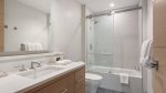 En suite bath featuring quartz vanity, LED mirror, and luxurious shower.