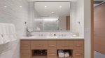 En suite bath featuring quartz vanity, LED mirror, and luxurious shower.
