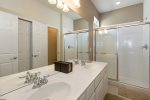 The en-suite bathroom has dual sinks and a walk-in glass shower