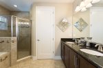 An en-suite bathroom with walk-in shower, dual vanity, and garden tub