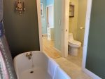 Sink and toilet behind another pocket door off laundry and tub room