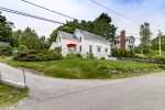 View of the house from the street and the off street parking. Can see guest cottage roof on left in proximity to main house