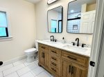 A clean, stylish bathroom with double sinks and a walk-in shower.