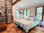 A wall of windows, soaring ceilings, and a ladder that leads straight into your next great read. This primary bedroom is full of charm and natural light.