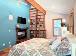 The primary suite is pure storybook charm. Vaulted ceilings, a full library wall with rolling ladder, and a dreamy view of the woods.