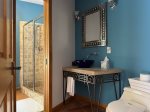 One of three full baths at Wildhaus, this main-level bathroom features a walk-in shower, bold cobalt accents, and artisan details throughout.