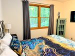 Fall asleep wrapped in gemstone hues and wake up to forest views. This queen bedroom is equal parts cozy retreat and colorful escape.