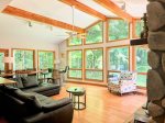 Soaring ceilings, panoramic forest views, and cozy seating make this light-filled living room the heart of Wildhaus.