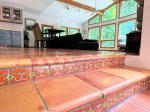Hand-painted tile risers and terracotta floors bring a touch of artisan charm to the open, light-filled living space.