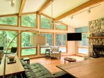 The view from every seat is pure Michigan magic: vaulted ceilings, a wall of windows, and a cozy stone fireplace set the tone for a peaceful, light-drenched retreat.
