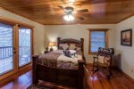 Queen bedroom with TV and private deck with mountain views