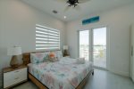 3rd level king bedroom with ensuite bathroom, smart TV, and access to balcony overlooking the pool and open water.
