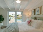 The master suite with a queen bed and direct backyard/pool and bathroom access.