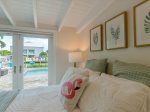 The master suite with a queen bed and direct backyard/pool and bathroom access.