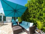 Covered outdoor seating with adjustable tilt umbrella.