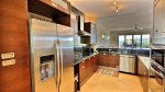 Kitchen with stainless appliances, dark cabinetry, elegant granite