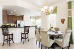 The dining area offers seating for 6 with 2 stools at the breakfast bar