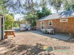 A gas BBQ, bench, lights, and a table are just off the kitchen.