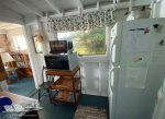 Small room off of kitchen with extra storage, microwave and fridge