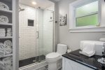 Full bathroom with custom tile walk in shower with glass surround