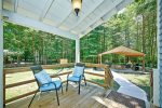 Deck just off the back of the house with a path to the covered patio 