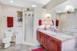 Primary bathroom with large vanity, separate shower, and large jetted tub