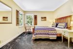 Guest bedroom with a queen size bed overlooking the patio and backyard