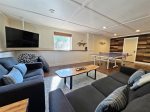 Lower level living space with Smart TV, plenty of seating, and a ping pong table 