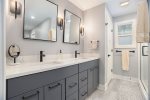 Primary bathroom with double vanity, step in shower, and separate toilet closet