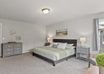 Primary bedroom upstairs with a king bed, Smart TV, work desk, and seating area 