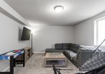 Lower level living area has a cozy sectional, smart TV, pop-a-shot basketball, and games 