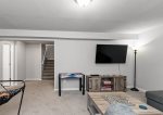 Lower level living area has a cozy sectional, smart TV, pop-a-shot basketball, and games 