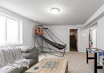 Lower level living area has a cozy sectional, smart TV, pop-a-shot basketball, and games 