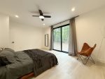 Spacious primary bedroom with a king bed overlooking the backyard 