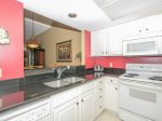 1839 Beachside Tennis`s updated kitchen looks out on to the main living area and balcony beyond