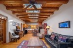 Open concept living area with gorgeous skylight and authentic viga ceilings