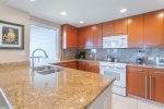 The fully remodeled kitchen is equipped with granite countertops and modern appliances, including a refrigerator, freezer, oven, stove, microwave and dishwasher