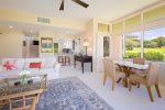 Adjacent to the living room, a dining table for four provides a welcoming space for meals with tropical views as your backdrop
