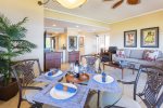 A dining table for four sits beside wrap-around windows, where expansive views of the resort set the stage for everything from sunlit breakfasts to intimate evening meals
